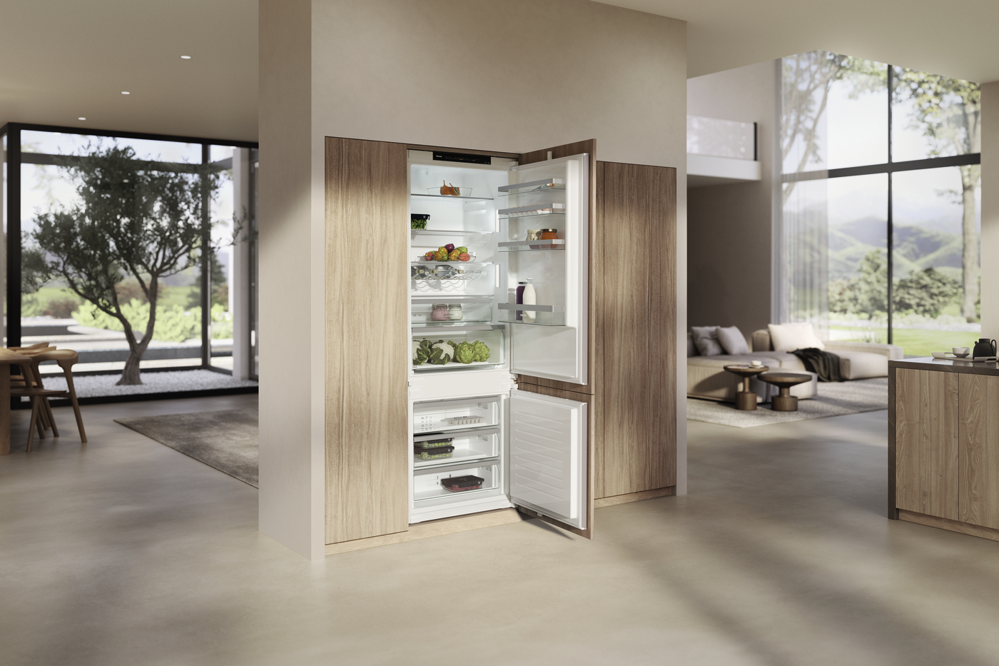 Open refrigerator built into wooden cabinetry in a modern kitchen, showing fresh produce and organized shelves inside and a bottom freezer drawer