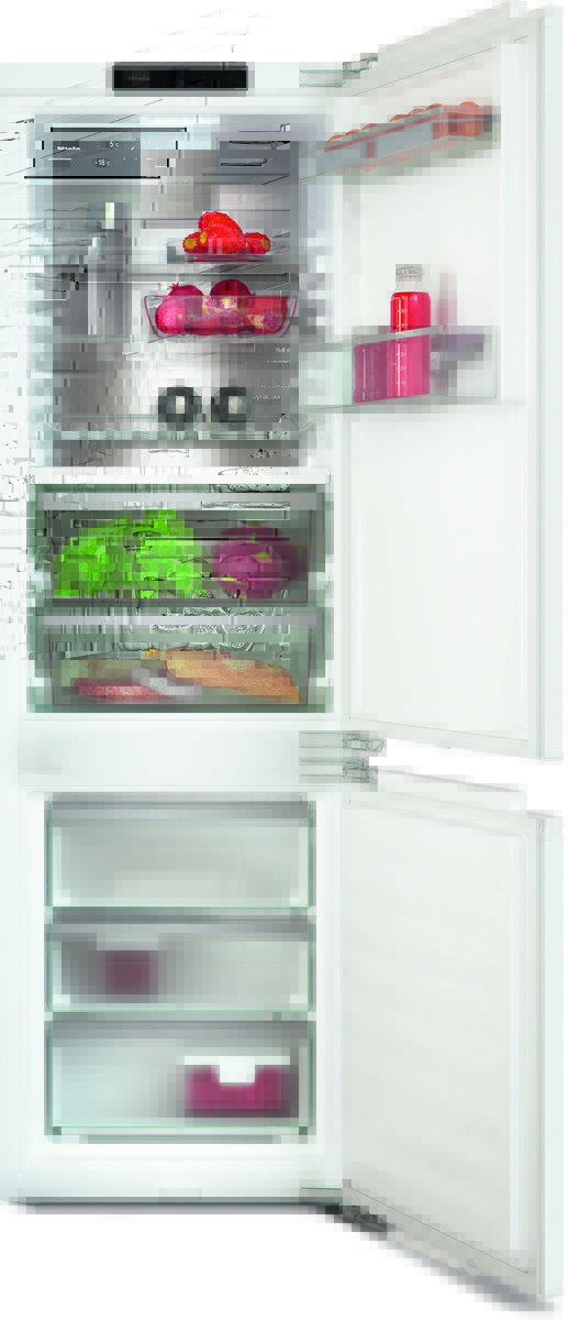 White, two-section refrigerator with top fridge and bottom freezer, open to reveal fruits, vegetables, beverages, and organized drawers.