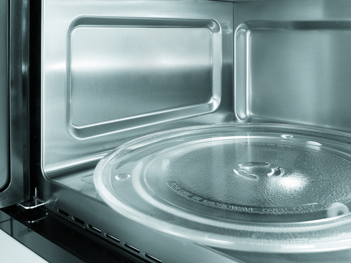 Interior of a stainless steel microwave with a round glass turntable
