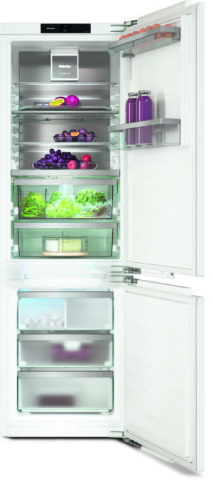 Open refrigerator showing organized shelves with fruits, vegetables, and purple juice in the door shelves.