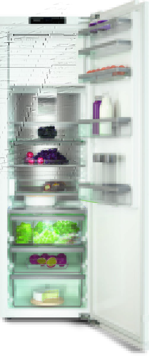 Open modern refrigerator with glass shelves filled with produce (grapes, leafy greens, citrus), dairy (milk), juice bottles, and a cake on the bottom shelf, all neatly organized.