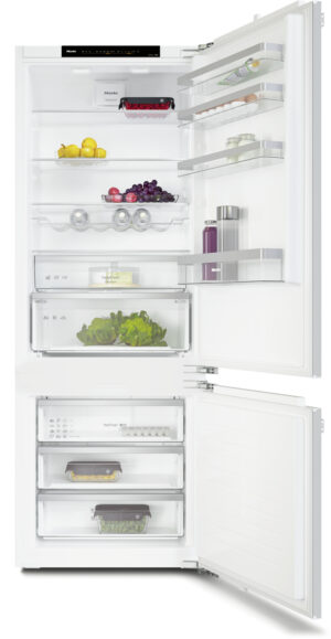 Open white refrigerator with fruits and vegetables on shelves and in drawers; bottom freezer with multiple trays clsd by door shelves with bottles nearby.
