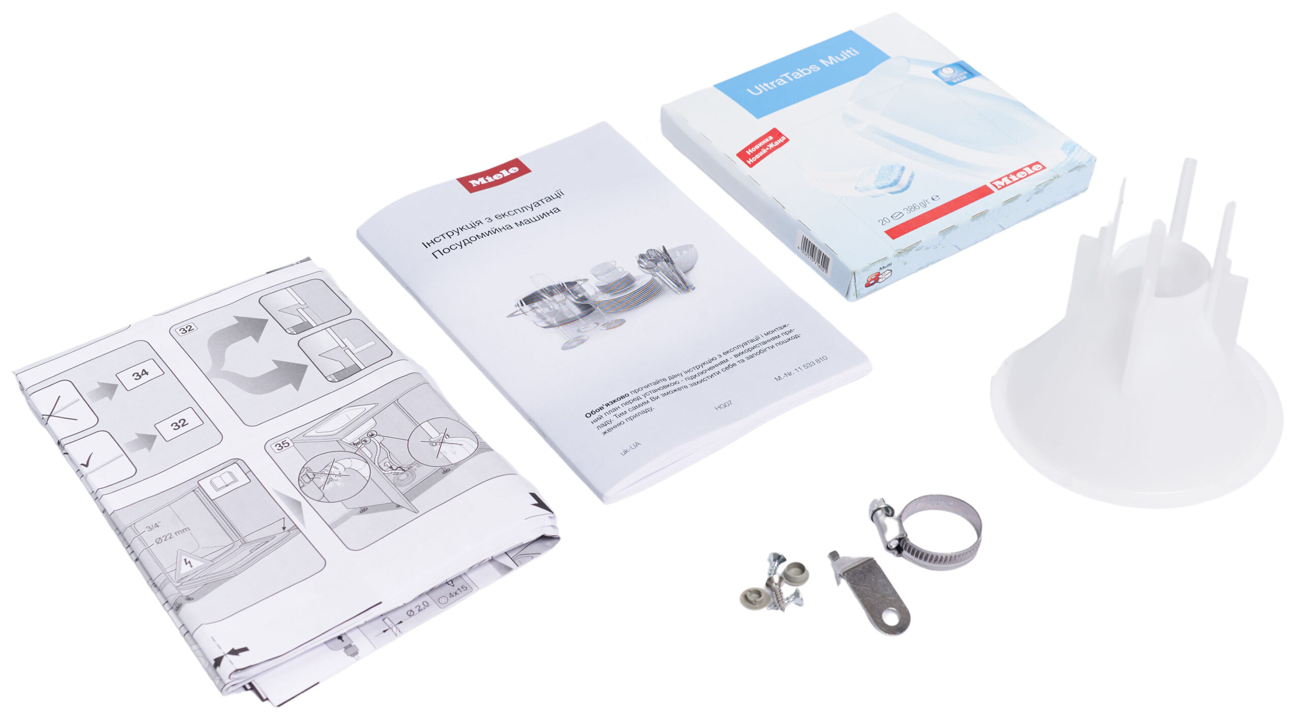 Assorted dishwasher manuals, a Miele box, and loose fittings laid out on a white surface.