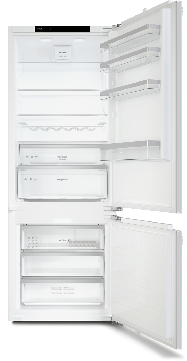 Tall white Miele refrigerator with doors open, showing empty upper fridge shelves, bottle rack, and a bottom freezer with three drawers/compartments.