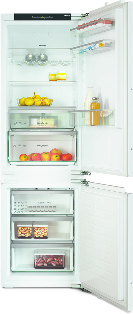 Open white refrigerator with organized shelves: apples and pears in a fruit bowl, dairy and juice in the doors, and a bottom freezer.