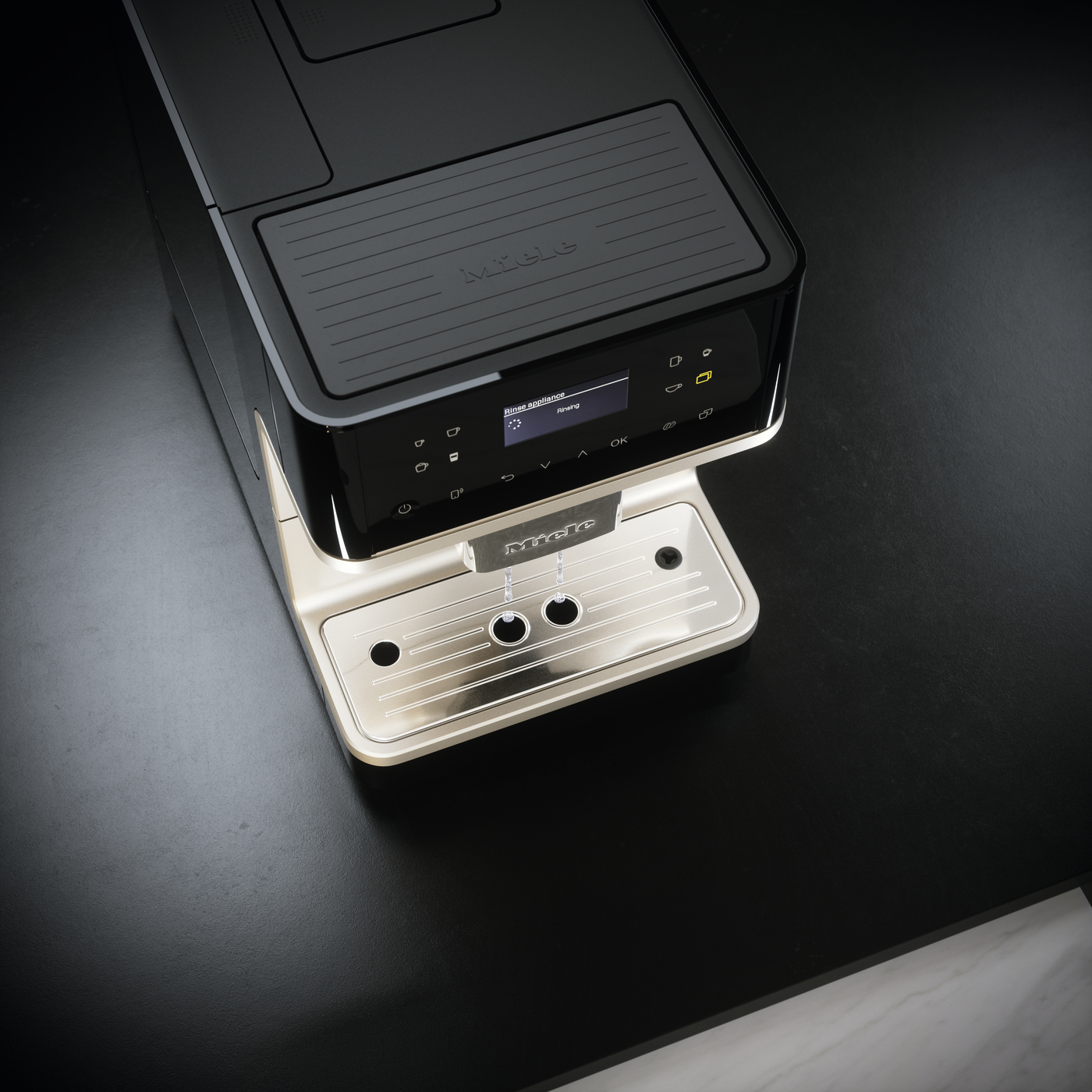 High-end black espresso machine with a metal drip tray on a dark countertop.