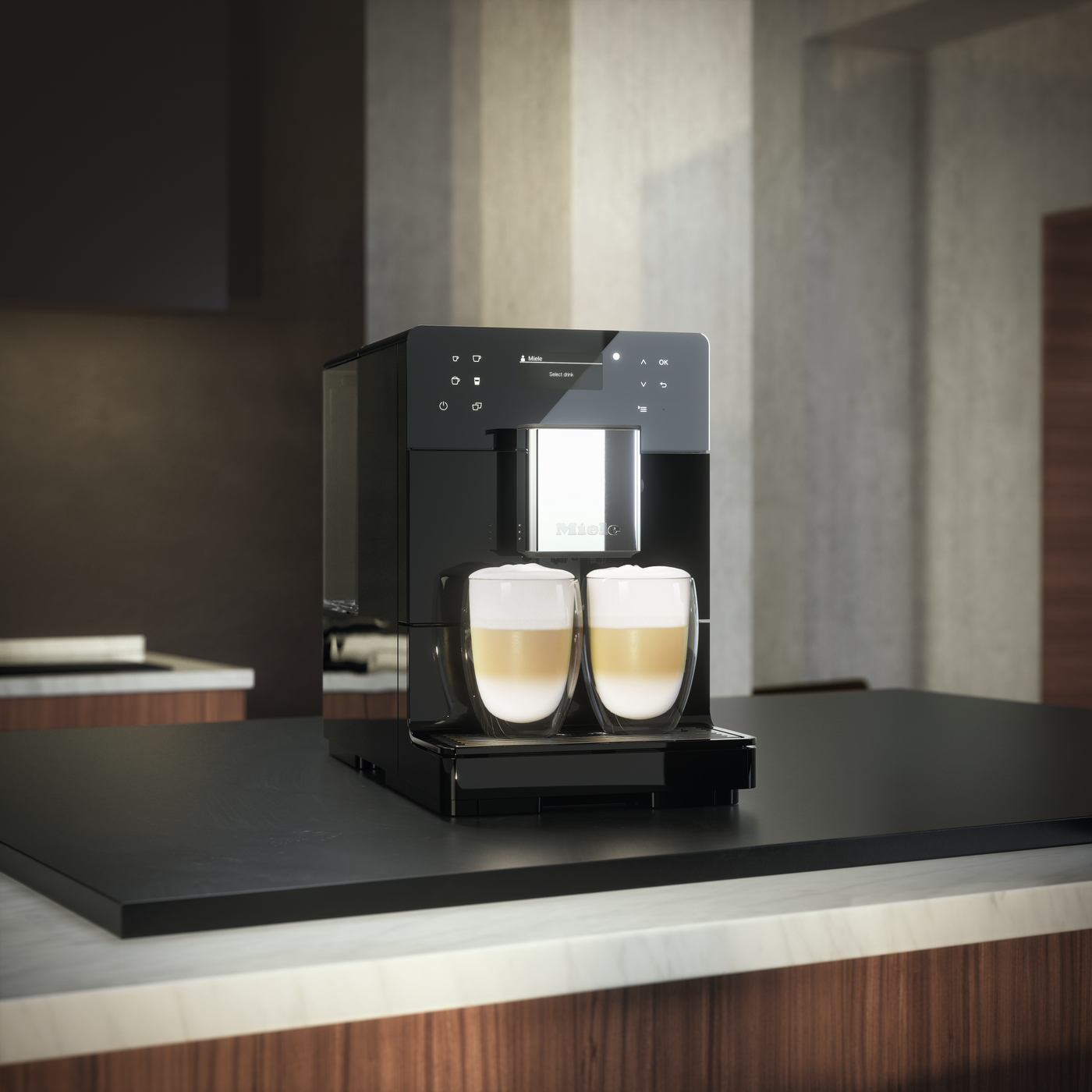 Sleek black espresso machine on a dark countertop with two glass mugs of layered coffee in front, ready to serve