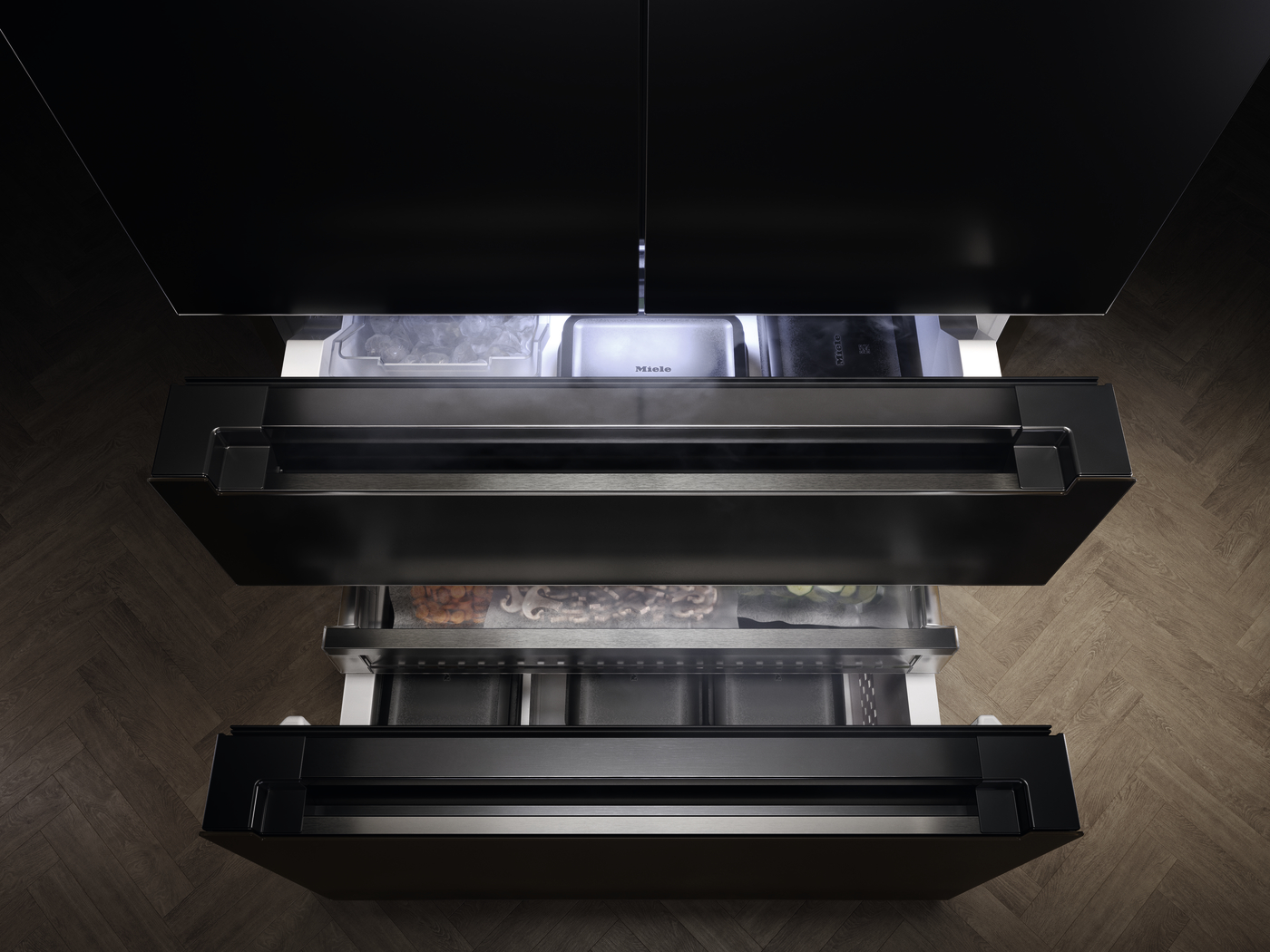 Top-down view of a black built-in kitchen drawer system with multiple pull-out drawers, one open to reveal storage compartments.