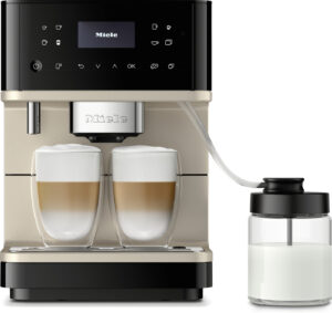 Miele coffee machine with two glass milk cups and a milk reservoir attached by hose.