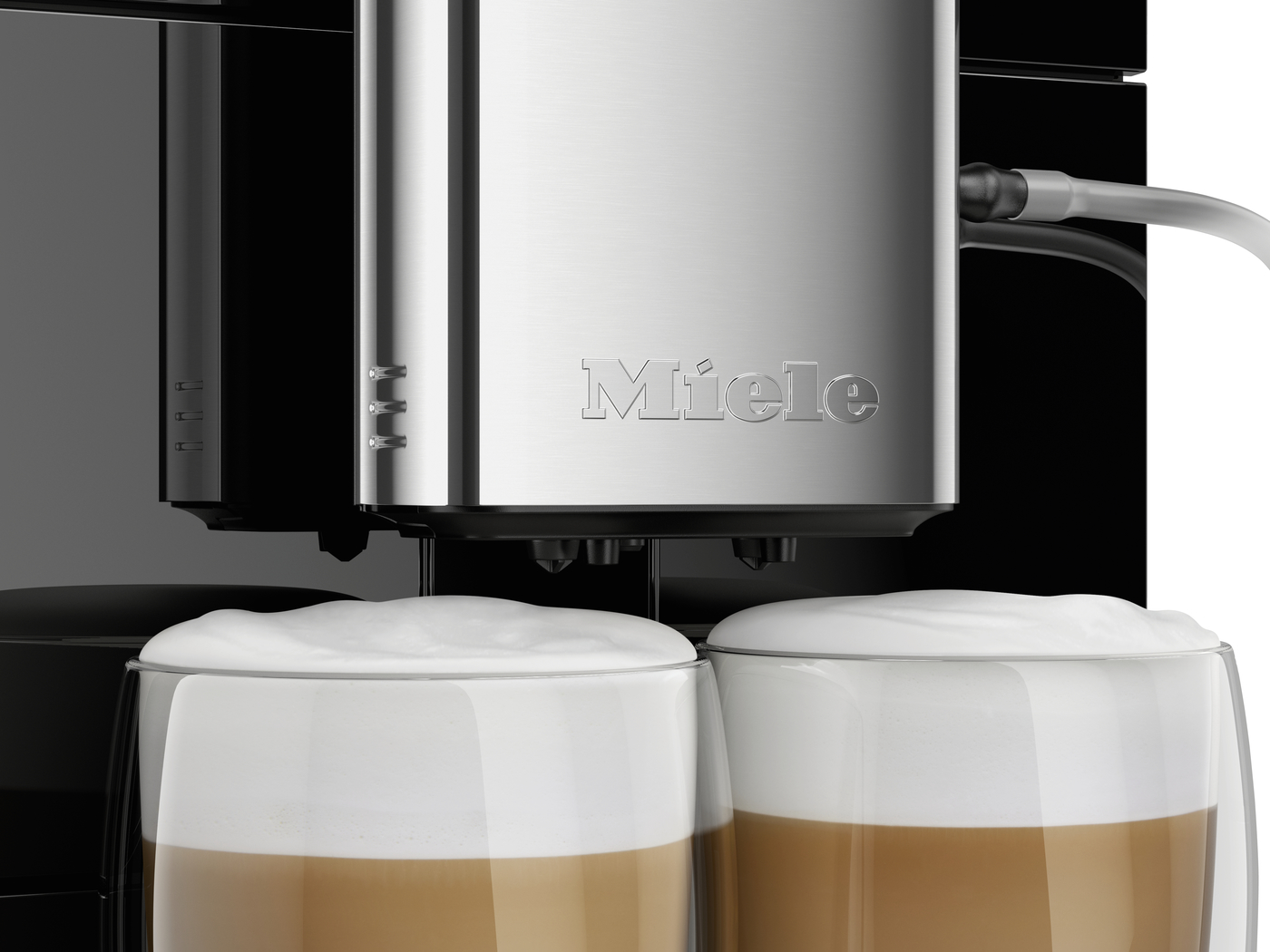 Miele espresso machine dispensing two cappuccinos into glass cups with thick milk foam