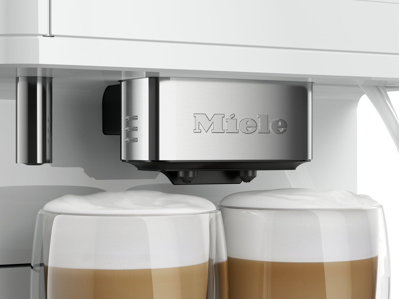 Miele espresso machine dispensing two layered coffee drinks into clear glasses with foam on top