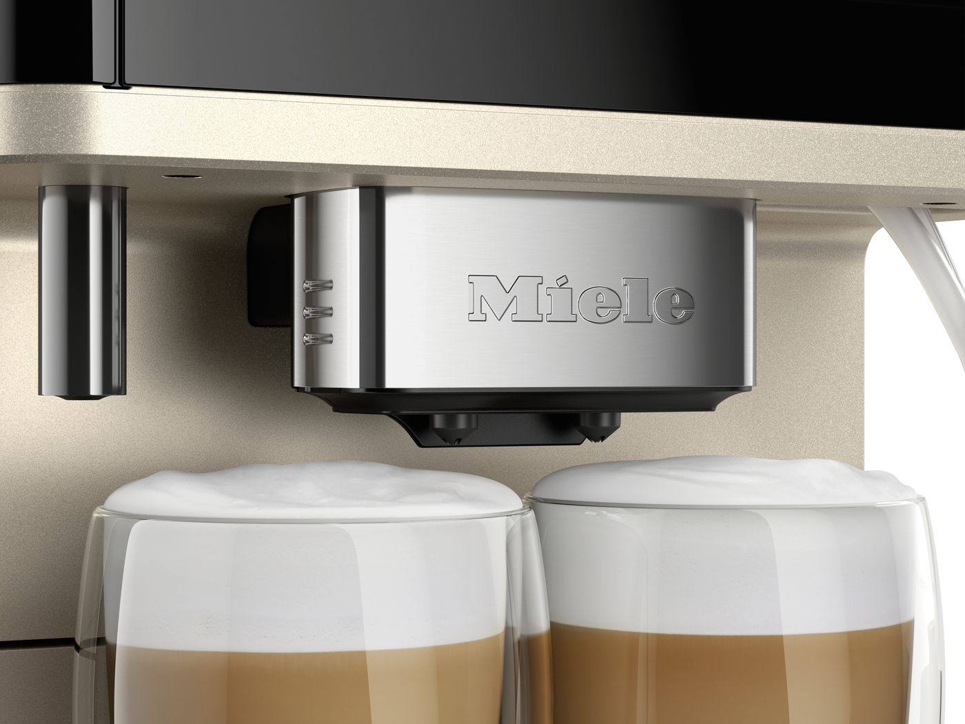 Miele espresso machine dispensing into two glass cups filled with layered coffee and milk foam.