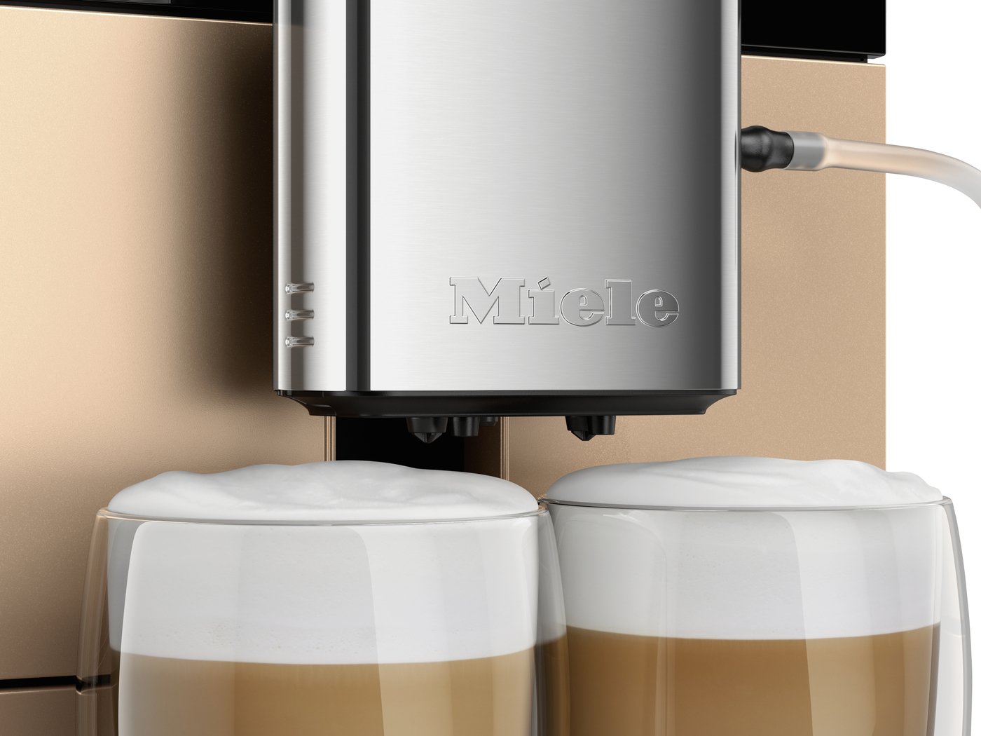Close-up of a Miele espresso machine dispensing two cappuccinos into clear glass cups.