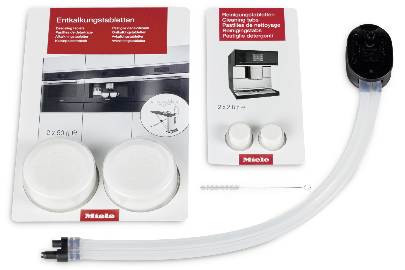 Miele descaling and cleaning tablet set with two white discs, cleaning tabs, a flexible hose, a small brush, and instruction cards.