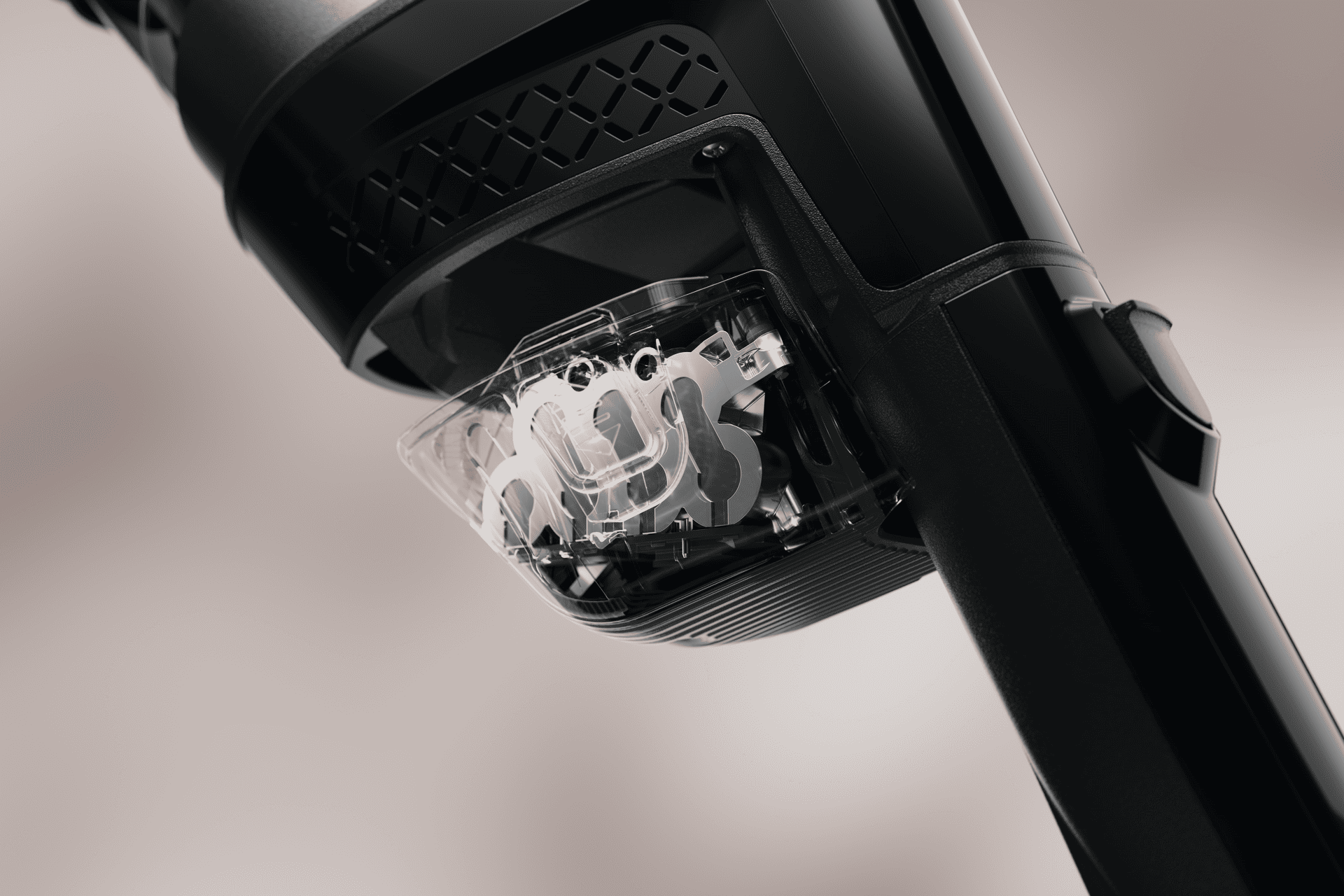 Close-up of a black mechanical device with a transparent casing revealing gears inside a sleek frame.