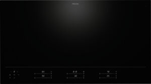 Miele induction cooktop with a sleek black glass surface and touch controls along the bottom edge.